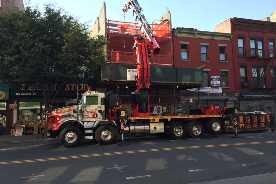 Boom crane truck lifting material in Brooklyn, NY